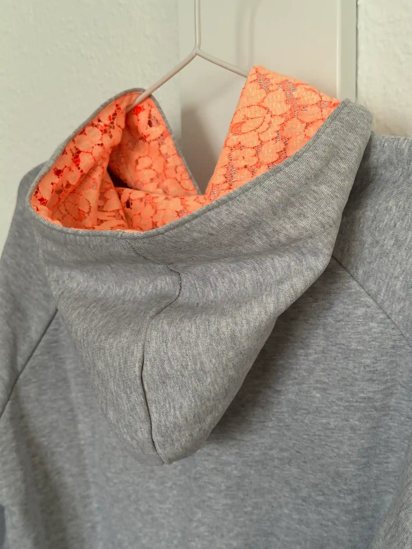 Hellgrauer Hoodie mit neonorangen Spitzendetails